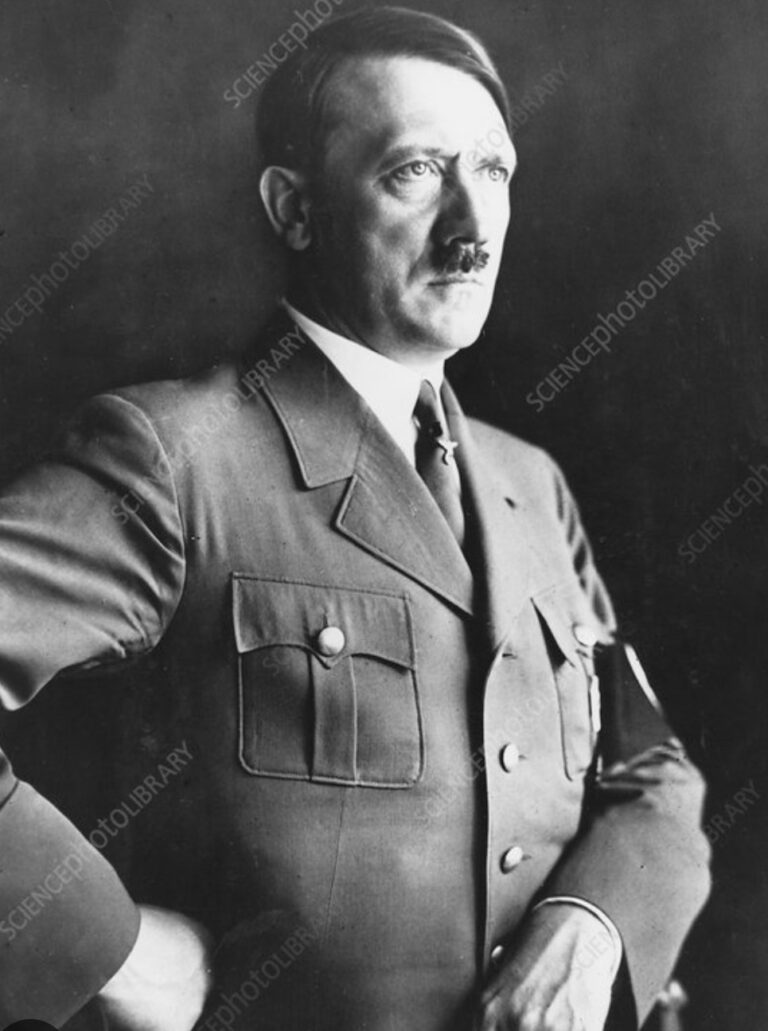 Black-and-white portrait of a man in a vintage military uniform, standing with his hand on his hip and looking off to the right.